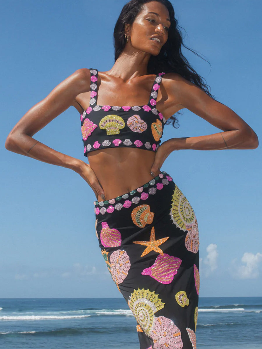 Woman with hands on hips by the sea wearing Oceanus beach clothes